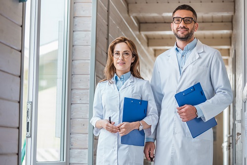 two veterinarians in white coats walking with clipboards in veterinary clinic